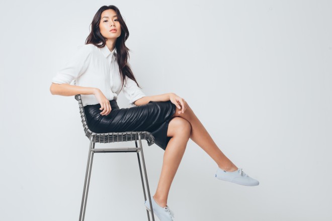 White dress shirt, Forever 21; leather skirt, River Island; white sneakers, Keds; metal chair, Crate & Barrel