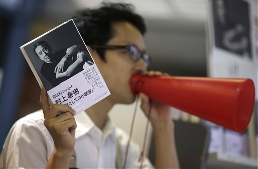 A salesclerk advertises Japanese novelist Haruki Murakami's new Japanese-language book, "Novelist as a Vocation," at Kinokuniya Bookstore in Tokyo Thursday, Sept. 10, 2015. For best-selling Japanese novelist Murakami, finding a market for his books seems an unlikely problem. His latest work, released Thursday was 90 percent spoken for weeks ago, when major book seller Kinokuniya ordered 90,000 out of the 100,000 copies of the first printing. (AP Photo/Eugene Hoshiko)