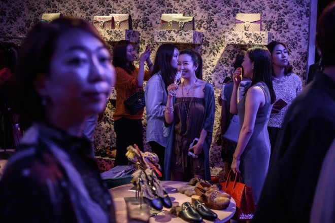 In a photo taken on September 4, 2015 people attend a Gucci 'pop-up store' event in the Gangnam area of Seoul. Seoul is emerging as Asia's new fashion showcase, with the world's top luxury firms seeking to cash in on the regional trend-setting popularity of South Korean pop culture. Fast-growing Asia is a key market driving the global luxury industry, with purchases by Chinese consumers accounting for one third of global sales, according to market researcher Bain & Company. AFP PHOTO / Ed Jones