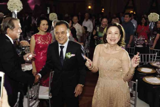 THE GOLDEN couplemake their entrance at Manila Polo Club, as sister Marilou (in red) and Ed Pineda cheer on.