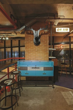 THE BLUE vintage record player, designed by Space Encounters, gives the music room a cool, crisp vibe. The cardboard moose head lends a quirky touch.
