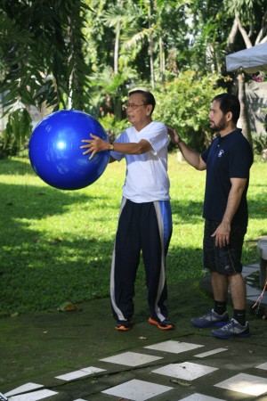 Ruben Tiosejo, 85, with trainer Sonny Orallo, executing ball twists to work and strengthen obliques and the lower back