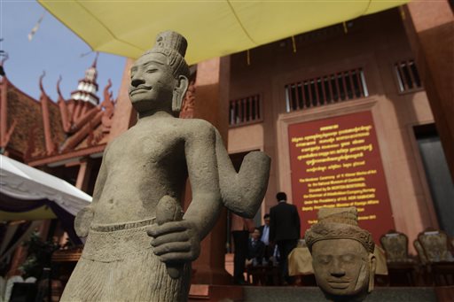 The head of Male Divinity statue, right, and other artifacts are on display during a ceremony after the artifacts were returned back from Norwegian collector Morten Bosterud, at Cambodian National Museum in Phnom Penh, Cambodia, Tuesday, Oct. 20, 2015. Cambodia welcomed home two stone statue from golden Angkor era that was looted from a temple during the country's civil war and spent the past three decades in abroad. (AP Photo/Heng Sinith)