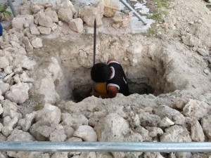 A WORKER digs a hole outside the walls of Dauis church in what used to be the foundation of a portico column