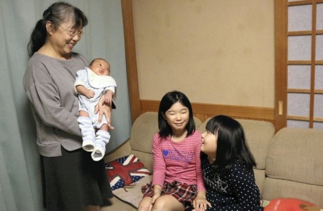 Fumiko Takano holds a grandchild, born in September, while talking with her two other grandchildren in Fukushima. Photo by The Yomiuri Shimbun