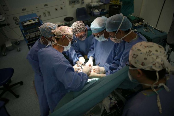 Professor Prabhakaran (fourth from left) and his team working together to remove Jeremy’s diseased liver. The operation was complicated by Jeremy’s earlier surgery, which had caused some scarring between the liver, and abdomen and intestines.ST PHOTO: WANG HUI FEN
