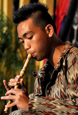 T’BOLI youth playing flute, clad in “’ t’nalak”’”