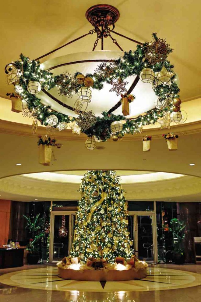 THEWREATHS and dangling boxes wrapping the chandelier were inspired by the “pabitin.”