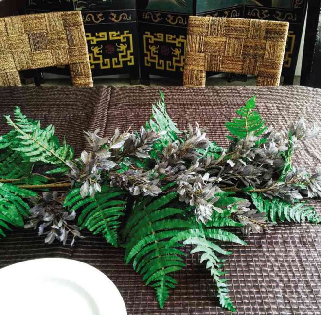 CREATE a bed of assorted foliage as the base of the centerpiece. Layer on the different varieties of leaves to achieve a lush garden-like landscape.