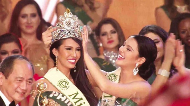 BACK-TO-BACK VICTORY FOR THE PHILIPPINES  Angelia Ong of Manila receives the 2015 Miss Earth crown from last year’s winner, Jamie Herrell of Cebu, in a back-to-back victory for the Philippines in the pageant’s 15th edition at Marx Halle in Vienna, Austria, on Saturday night. Ong bested contestants from more than 80 countries. PHOTO FROM THE MISS EARTH TWITTER PAGE