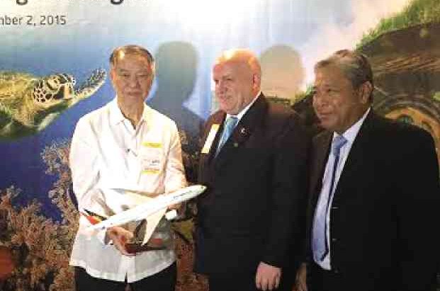 LUCIO Tan, PAL chair, presents a gift to New Zealand Ambassador to the Philippines David Strachan at Naia Terminal 2 before PAL’s inaugural flight from Manila to Auckland. With them is PAL president Jaime Bautista. 