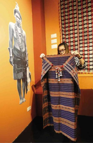 MUSEUM guide Stella Gaspar holds up a boy’s cape from the Gad’dang tribe.