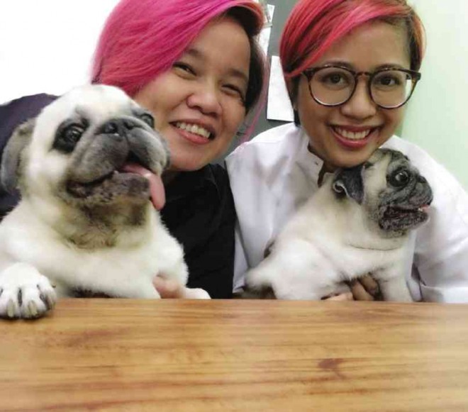 LIFESTYLE reporters Anne A. Jambora and Cheche V. Moral with their pugs Lord Trojan Spike, 10, and Missy Elliot, 11 (who was not in the mood to be photographed)
