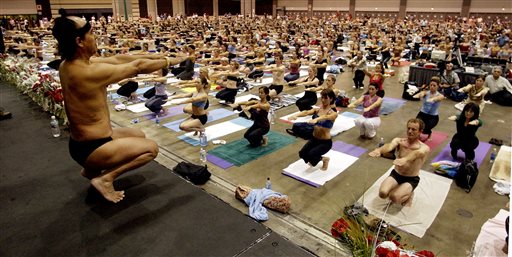 In this Sept. 27, 2003, file photo, Bikram Choudhury, front, founder of the Yoga College of India and creator and producer of Yoga Expo 2003, leads what organizers hope will be the world's largest yoga class at the Expo at the Los Angeles Convention Center. A Los Angeles jury on Monday, Jan. 25, 2016, ordered Choudhury to pay $924,500 in compensatory damages after finding he had subjected a lawyer to harassment and retaliation. AP FILE PHOTO