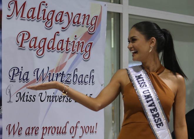  Miss Universe 2015 Pia Alonzo Wurtzbach gestures as she is met by supporters and the media upon her arrival at Terminal 2 in Manila International Airport.  EDWIN BACASMAS