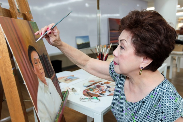 Carolina Llanillo painting a portrait of her brother-in-law