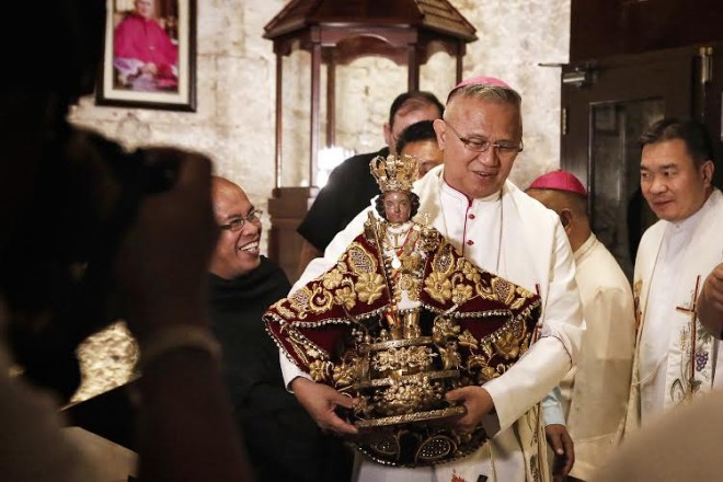 ARCHBISHOP José Palma of Cebu carries the Señor Santo Niño image at the Basilica rector’s office. PAUL ALLYSON QUIAMBAO