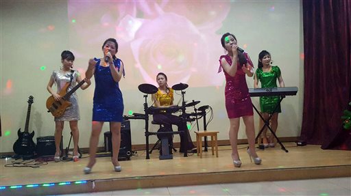 In this Feb. 18, 2016, photo, North Koreans who are also the waitresses and the singers perform at the Pyongyang A Ri Rang Restaurant in Bangkok, Thailand. The Bangkok show was a half-hour of skilled performances and lightning-fast costume changes, from traditional hanboks to sparkly short dresses in the style of K-pop girl bands. A slideshow in the background depicted flowers, landscapes, tundra and a river full of dead fish. (AP Photo)