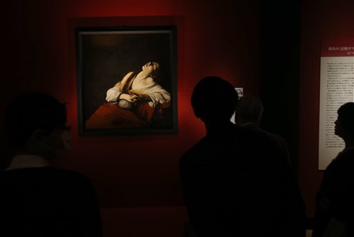 People look at "Maria Magdalene in Ecstasy" by Italian maestro Caravaggio during the media preview prior to the opening ceremony of the "Caravaggio and His Time: Friends Rivals and Enemies" exhibition in Tokyo, Monday, Feb. 29, 2016. The painting, which was discovered in 2014 by a leading Caravaggio scholar among his family heirlooms after being lost for more than 400 years, will be shown to the public for the first time in the world at the exhibition starting Tuesday, March 1 along with his 10 other paintings at the National Museum of Western Art in Tokyo. AP PHOTO