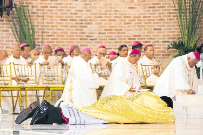 Macaraeg lies prostrate at the St. John the Evangelist Cathedral during his episcopal consecration.