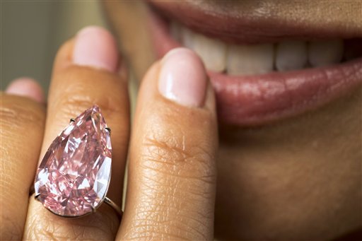 A model displays "The Unique Pink", the largest Fancy Vivid Pink pear shaped diamond ever offered at an auction, during a Sotheby's press preview in Geneva, Switzerland, Monday, May 9, 2016. AP