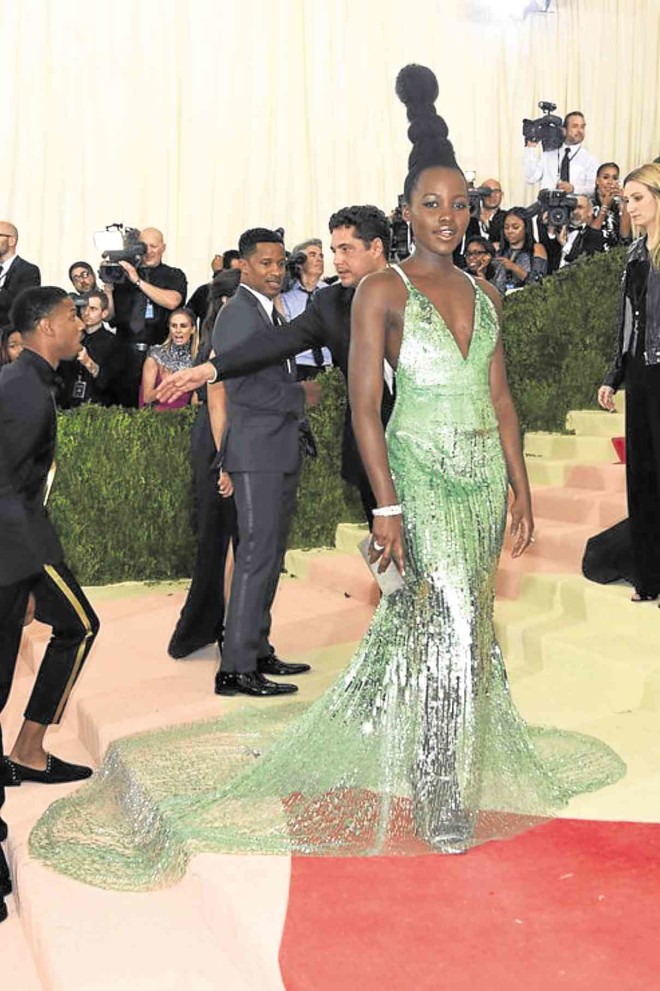 LUPITA Nyong’o in a Calvin Klein green-and-silver sheer number balanced by a ’60s hairdo