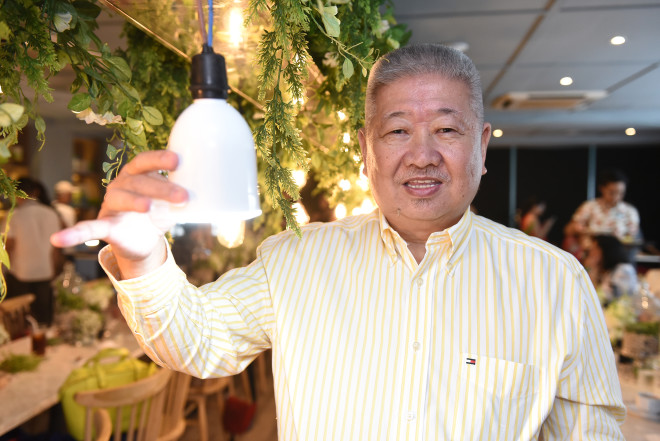 Johnny Chan, president of Rockford Marketing Corp. holds a bluetooth enabled LED bulb