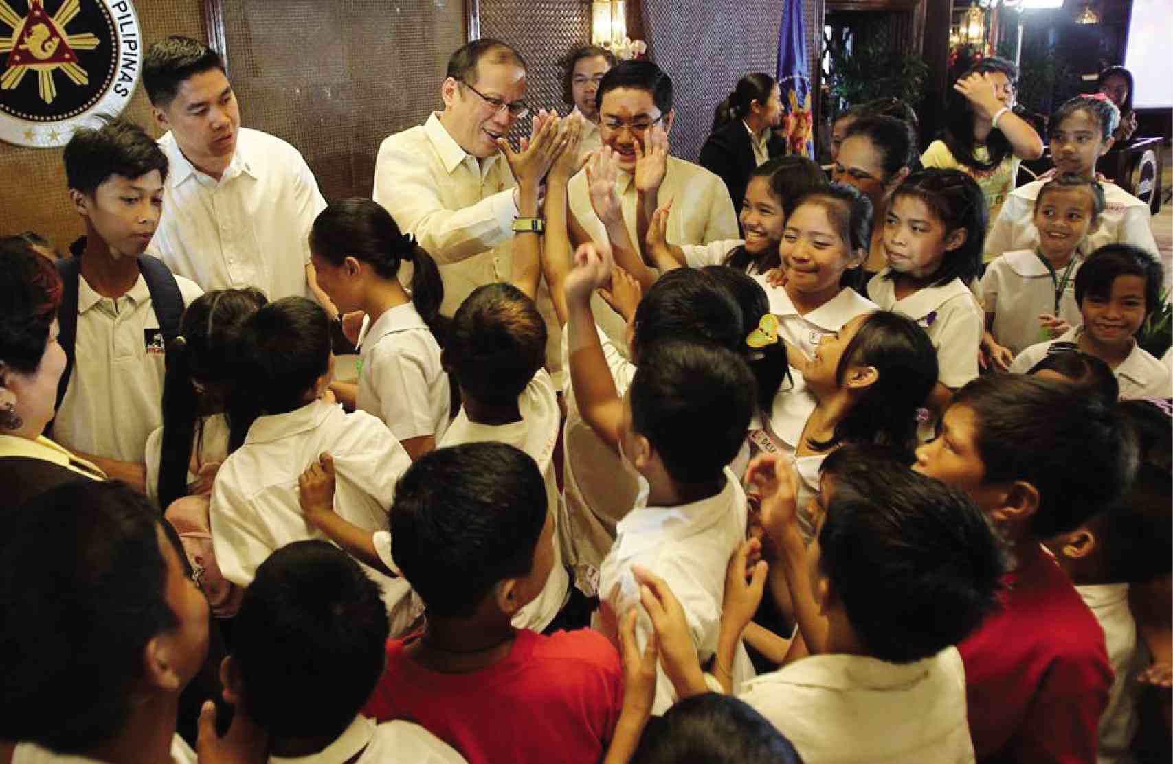 PRESIDENT Aquino high-fives the children after the signing of the Children’s Emergency and Relief Protection Act atMalacanan last week. PHOTO FROM PRESIDENT AQUINO’S FACEBOOK PAGE