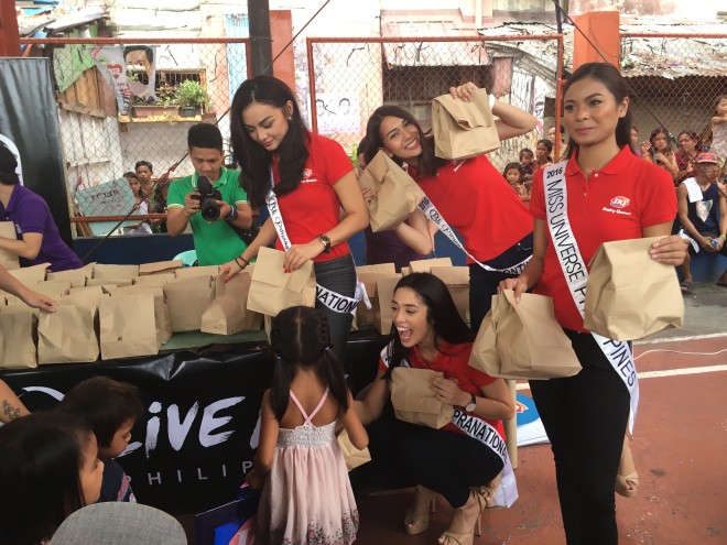 (From left) Bb. Pilipinas queens Verzosa, Eden, Hammond, and Medina distribute snacks to school children in Tondo. YUJI GONZALES/INQUIRER.net