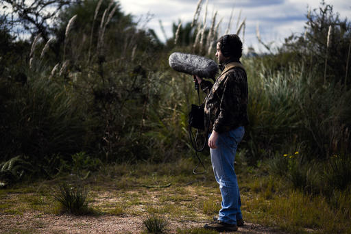 In this June 1, 2016 photo, Juan Pablo Culasso stands with his recording equipment in a natural reserve on the outskirts of Montevideo, Uruguay, Wednesday. He said he discovered his calling as a teenager, when he joined an ornithologist on a 2003 field visit, inspired by his love of birds. The bird expert gave him a recorder, and he was hooked. Culasso's passion now is to record and learn from the sounds of nature. (AP Photo/Matilde Campodonico)
