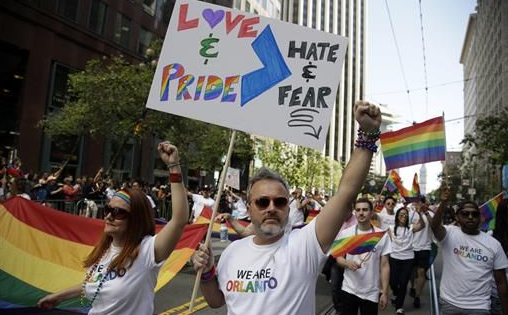 odd Elmer, center, and, Rachel Payne, left, march during the San Francisco Gay Pride parade Sunday, June 26, 2016, in San Francisco. Parades in San Francisco and other major cities Sunday featured increased security, anti-violence messages and tributes to those killed in this month's massacre at a gay nightclub in Florida. (AP Photo/Marcio Jose Sanchez)