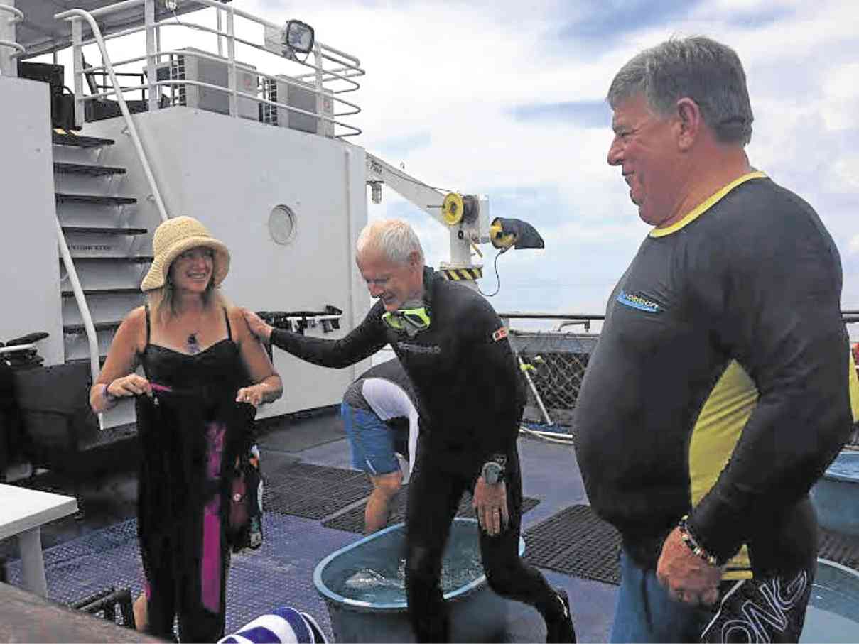 ASIA Divers’ Allison Manis with divers Gunnar Sekander and Frank Craven gears up on the deck. ALYA HONASAN