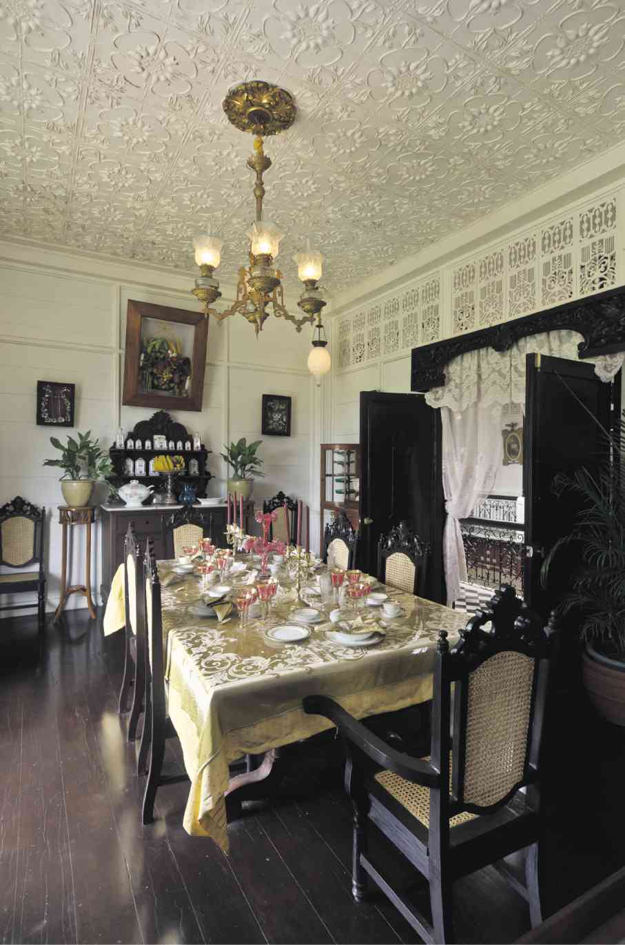 elaborate pressed tin ceiling, cutwork transoms and carved valances in the floral style in the dining room