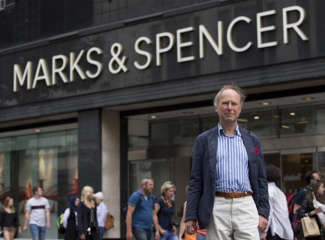 Nigel Rodgers of the Pipedown campaign group poses for a photograph in front of a branch of Marks and Spencer on Oxford Street in central London on August 18, 2016. Nigel Rodgers has campaigned against the canned music which is common in British shops and other public spaces for 24 years but his group Pipedown recently scored its biggest success yet. One of the country's top department stores, Marks and Spencer, said it would stop playing music after a letter writing campaign by hundreds of Pipedown's 2,000 members.  / AFP PHOTO / JUSTIN TALLIS / TO GO WITH AFP STORY BY KATHERINE HADDON