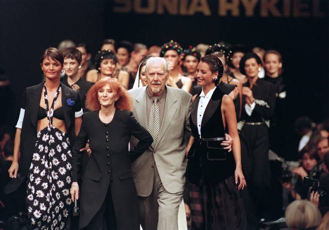 (FILES) This file photo taken on October 10, 1993 shows French designer Sonia Rykiel (2-L) flanked by Danish model Helena Christensen (L), American Christie Turlington (R), and American director Robert Altman, acknowledges the public at the end of her ready-to-wear spring-summer 1994 fashion show in Paris.  French fashion designer Sonia Rykiel, the so-called Queen of Knitwear, died on August 25, 2016 at the age of 86 after a long battle with Parkinson's disease, her daughter told AFP. / AFP PHOTO / GERARD JULIEN