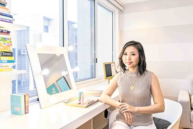 MOMPRENEUR Jacque Gutierrez sits in front of themakeup mirror in the office/guest room.With her experience and contacts in the cosmetics industry, she developed her ownmakeup and skincare line for Filipino women.