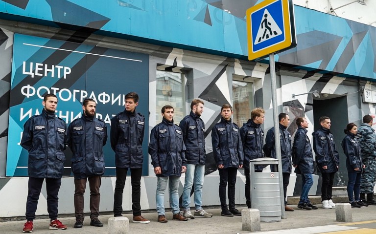 Some 20 activists in matching uniform jackets and camouflage from a little-known non-governmental organisation called "Officers of Russia" stand outside the doors of the Lumiere Brothers Gallery close to the Kremlin in Moscow on September 25, 2016. Pro-Kremlin activists threw urine on pictures by a controversial US photographer at a Moscow gallery and forced the show's closure after a government advisor condemned the images as "child pornography". The exhibition showed pictures by Jock Sturges, a well-known photographer whose nude images of children have regularly prompted accusations of paedophilia, which he denies.  / AFP PHOTO / Andrei BORODULIN