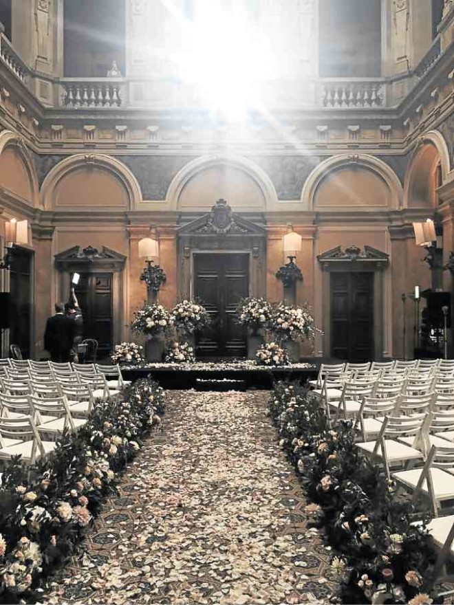 VILLA Erba hall, its path strewn with petals, where nuptial rites are held