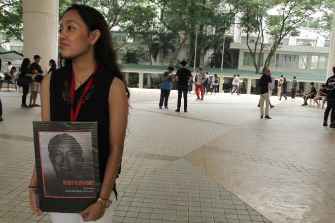 STUDENT holds a photo of martial law victim Rudy Romano.