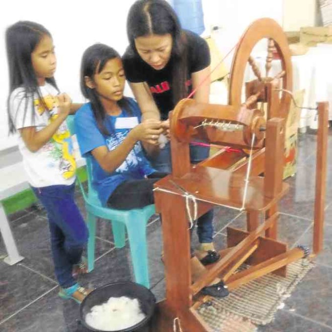 YOUNG girls try their hand at the loom during a spinning module held in Iloilo