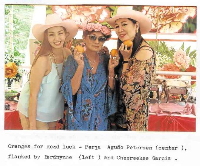 Oranges for good luck. Perla Agudo Petersen (center), flanked by Berdynne and Cheereekee Garcia