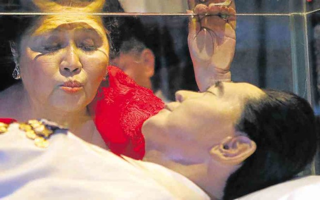 ImeldaMarcos kisses her husband’s glass coffin in Batac, Ilocos.