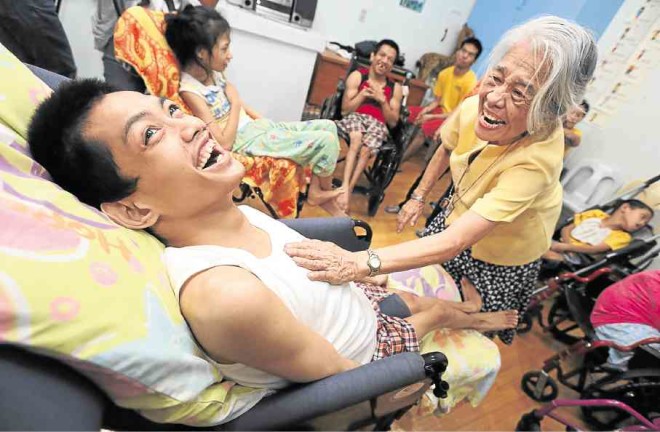 FUN TIME AtHandicap Center Lourdes inside Caritas Pandacan, Celeste Sanchez uses music to interactwith PWDs, teaching them to breathe properly through the diaphragm (above), or forming an impromptu orchestra using small instruments that she herself brings (below).