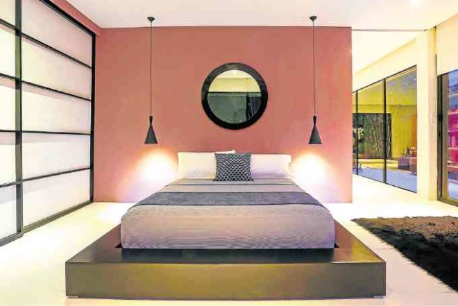 SANCTUARY FOR THE SENSES Devoid of any superfluous objects, the minimalist master bedroom is furnished with a platform bed. “Shoji” screens slide to conceal closet space. The sliding door separates the bedroom from the living room.