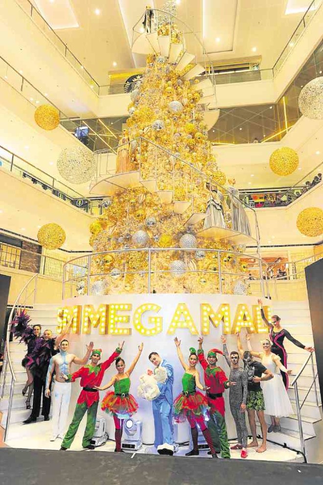 SM Megamall's 30-foot revolving gleaming Christmas tree features the glamorous gowns for the Red Cross ball by designers Ivar Aseron, Rhett Eala, Jun Escario, Rajo Laurel, Francis Libiran, Dennis Lustico, Yvette and Choc Religioso, Joey Samson and Cary Santiago.