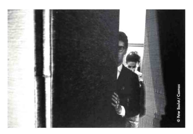 A visibly anxious Yves Saint Laurent peeks out from backstage during his first collection show in 1962, heralded by the industry as the birth of fashion’s new era.