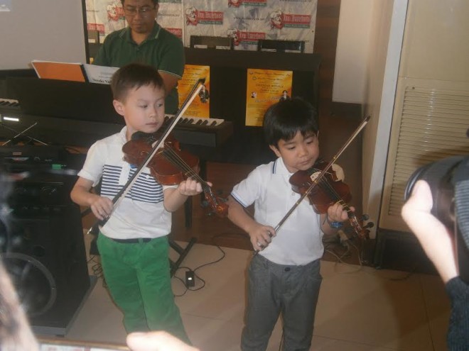 Violinists Teddy Tan, 7, and Red Lanete, 5