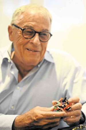 Jeweler and sculptorHans Brumann, shows off a delicate brooch pendant influenced by a J. Elizalde Navarro painting.