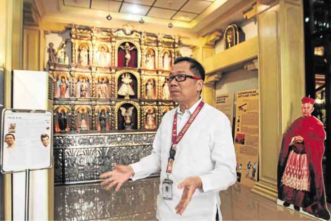 Robby Tantingco, Kapampangan Studies Center director, with altarpiece of patron saints in their original iconography