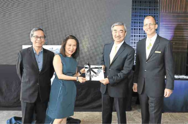 Elizabeth Sy and Hans Sy show the book, “The Art of Conrad.” They are flanked by Nestor Jardin and Conrad Manila general manager Harald Feurstein.